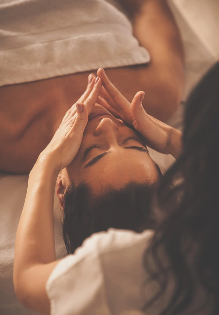a woman laying on top of a bed with her hands in the air